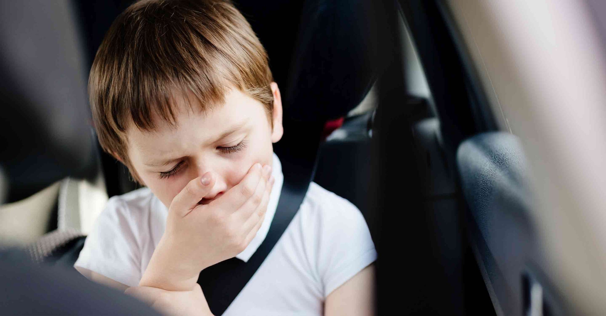 Kid coughing in the back seat of a car